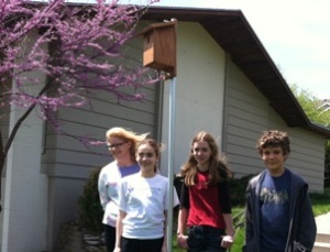 Teens standing around their finished birdhouses