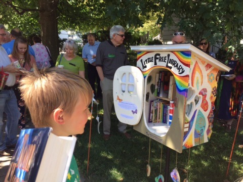 Children and adults admiring the colorful little free library