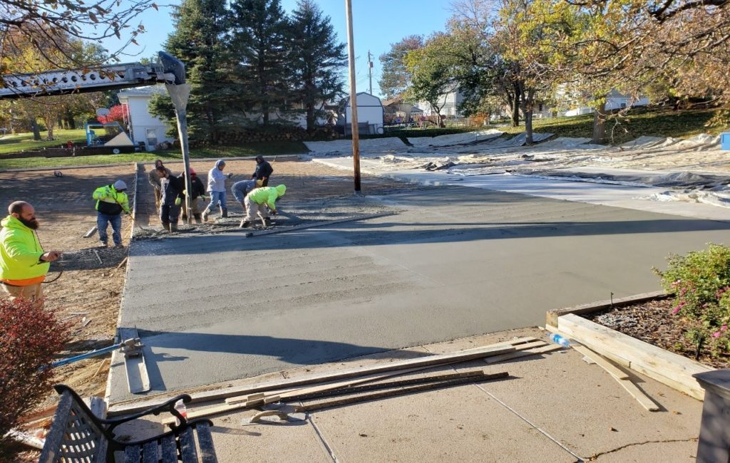 Workers pouring concrete on the mid-section of the church parking lot