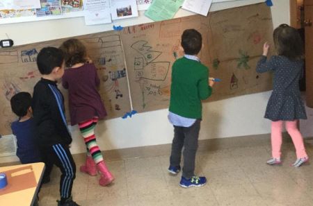 Children drawing on a wall mural during Children's Sunday morning religious education.